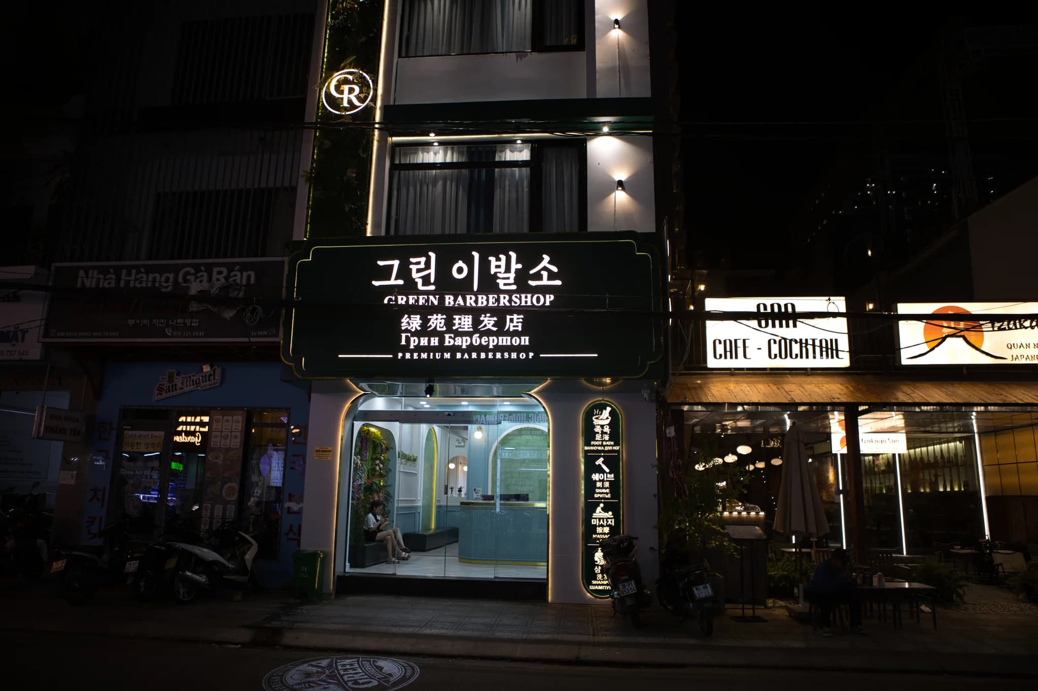 조명이 켜진 그린이발소 한글 간판과 유리 출입문이 보이는 야간 외관